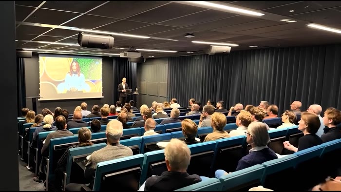 A full lecture theatre watching a talk